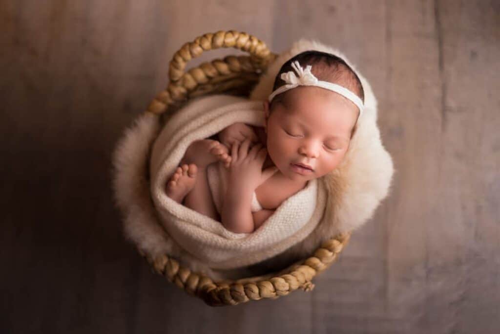 A New-born girl in a prop basket